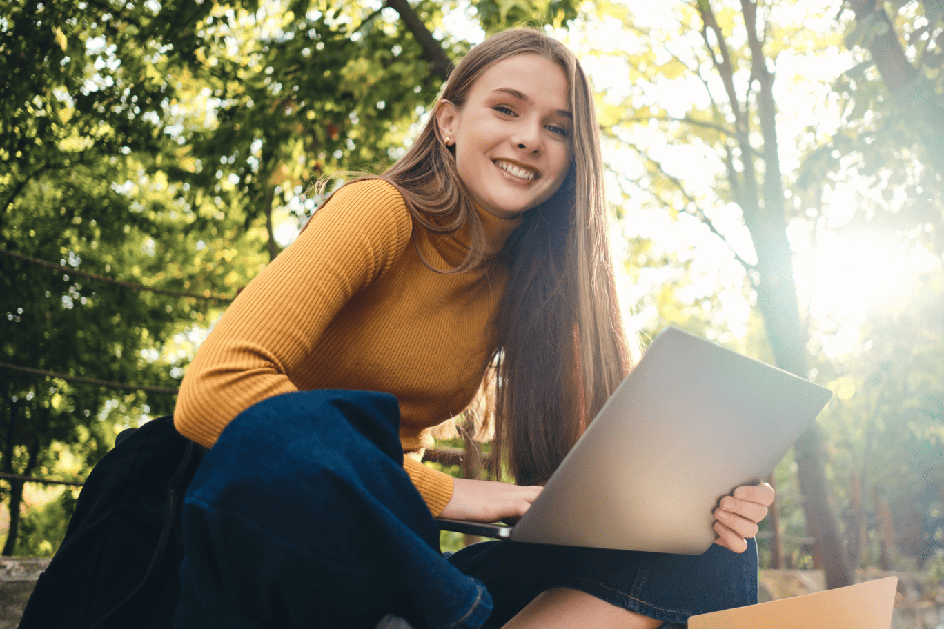 IMMAGINE RAGAZZA MAGLIA SENAPE JEANS MACBOOK SEDUTA BIONDA AIUTOTESI